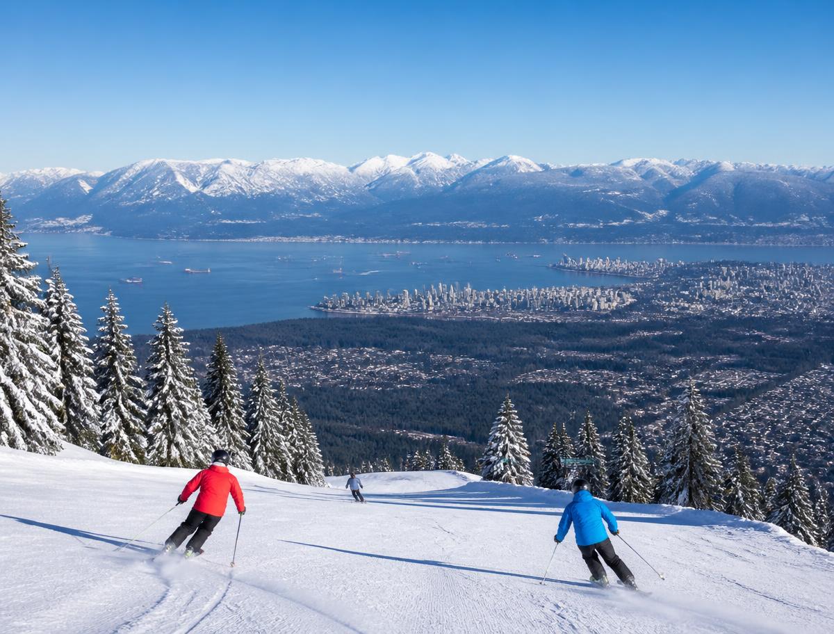 Skiers on a groomed run above Vancouver with the city and ocean visible below under a clear winter sky